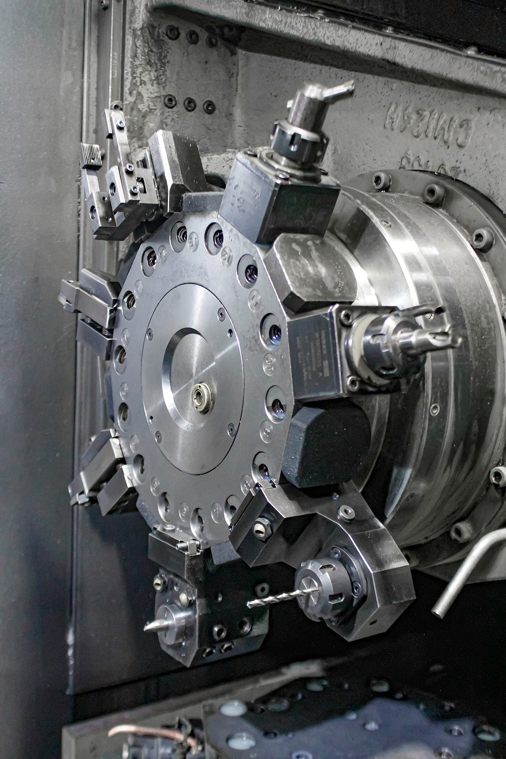 Precision turning machine showing rotating tool head in a factory environment.