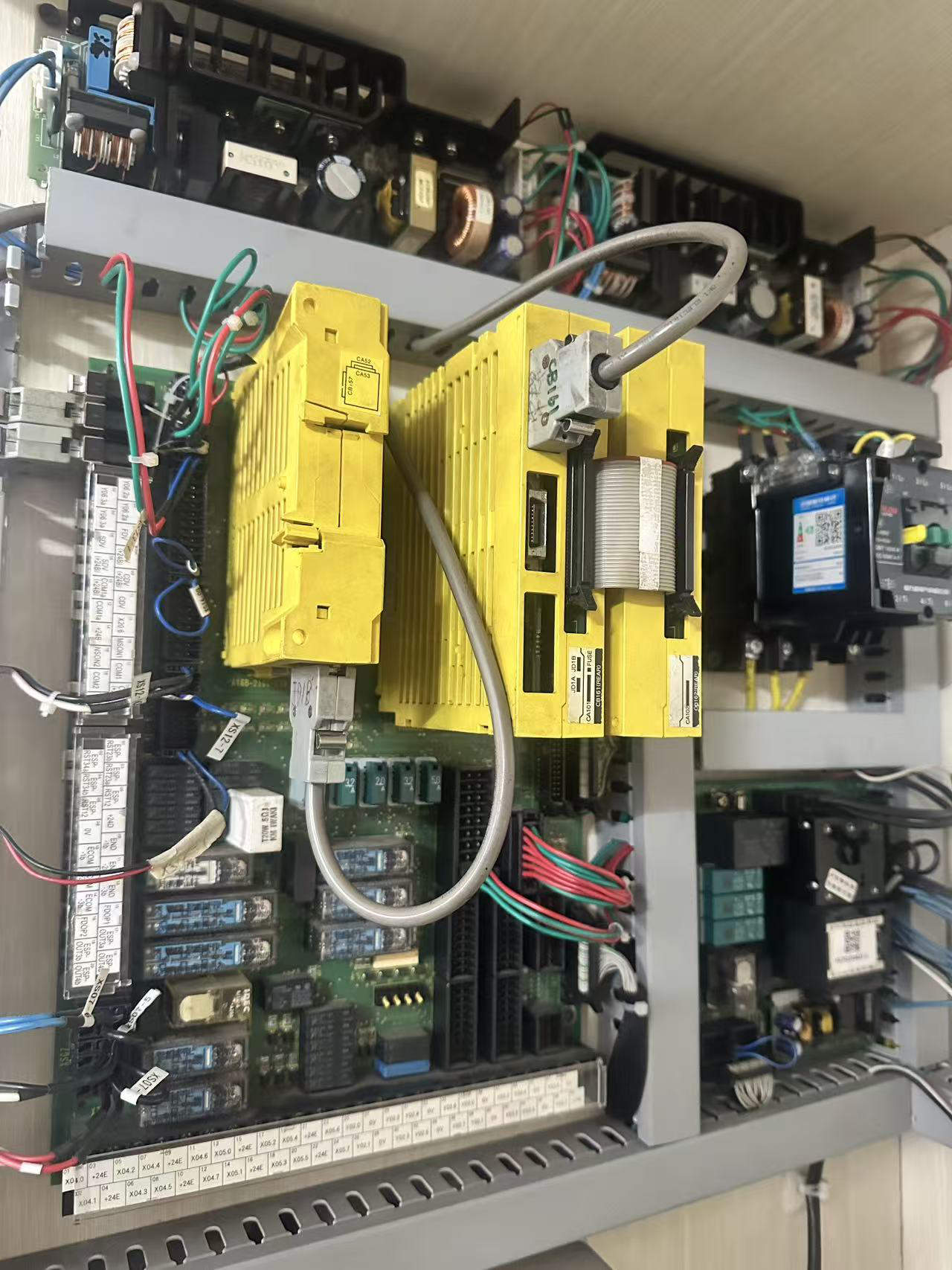 Fanuc I/O board connected to two I/O modules with system and external device wiring on REACO CNC testing setup.