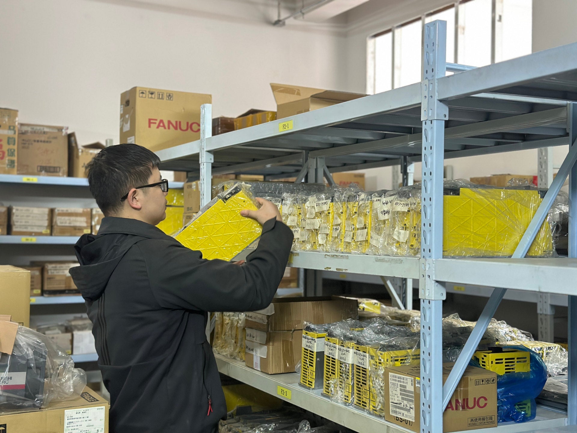 REACO CNC staff organizing and handing CNC components in warehouse